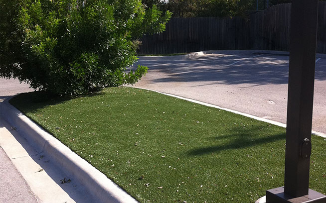 Strip of artificial grass beside a commercial property walkway